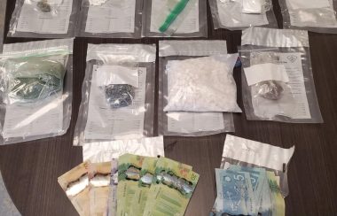Plusieurs sacs de drogues et de l'argent étalés sur une table