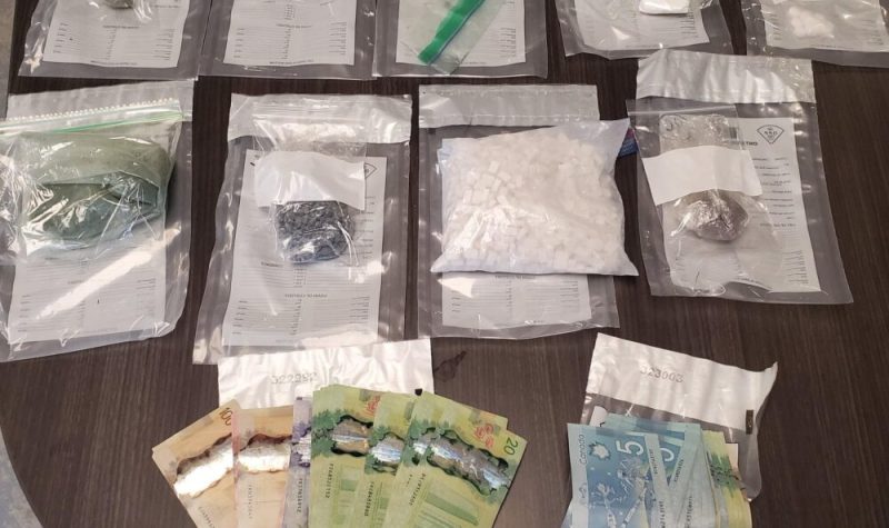 Plusieurs sacs de drogues et de l'argent étalés sur une table