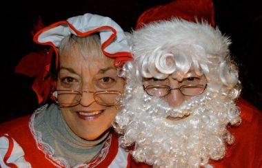 Homme déguisé en Père Noël et femme déguisée en Mère Noël.