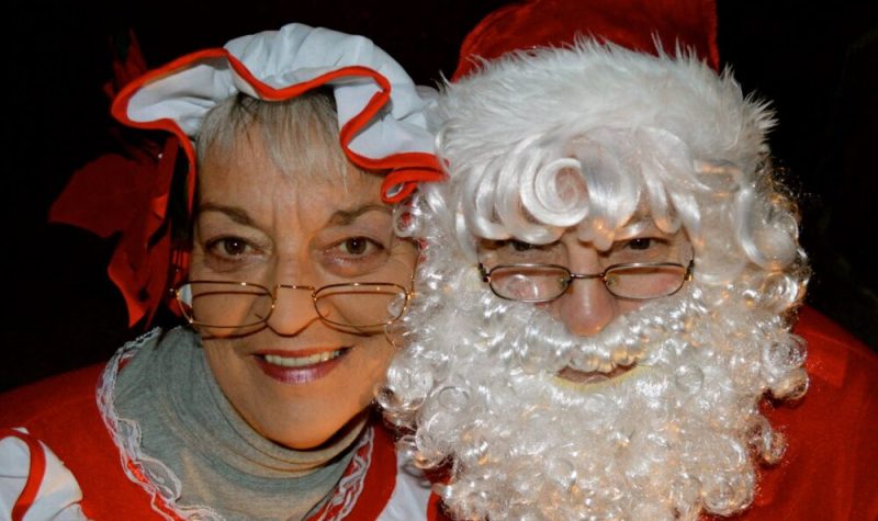 Homme déguisé en Père Noël et femme déguisée en Mère Noël.