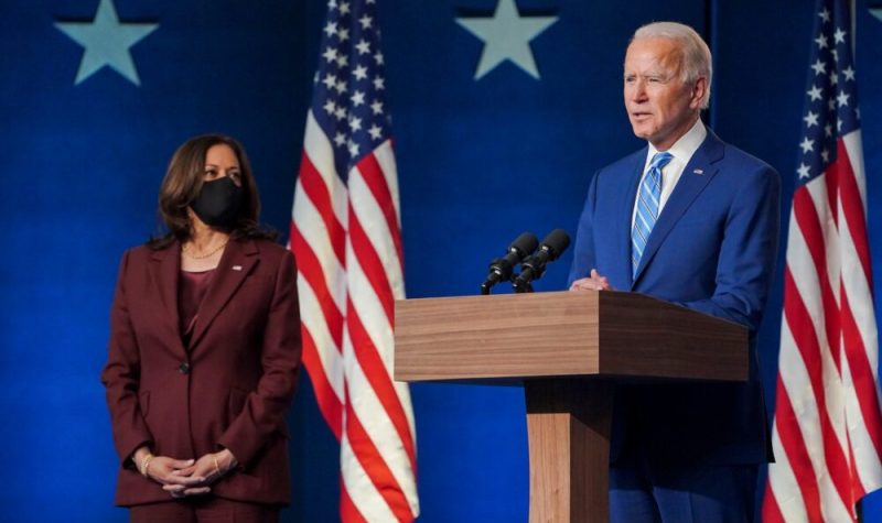 Joe Biden prononce un discours devant un lutrin, Kamala Harris en arrière plan