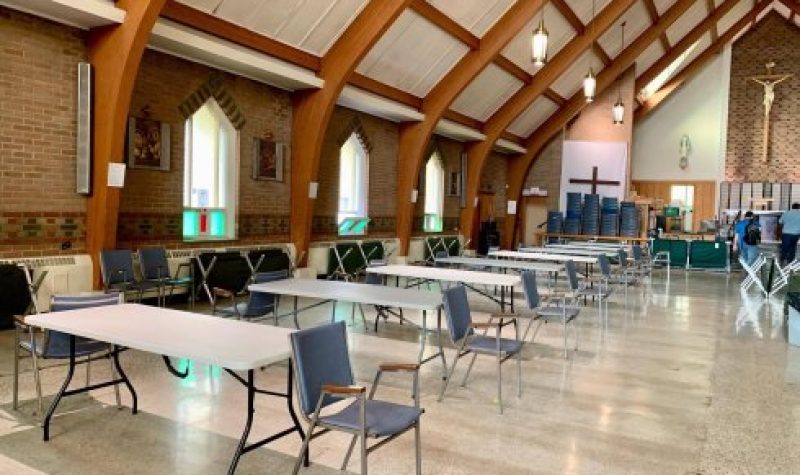 L'intérieur d'une église avec des tables et des chaises occupant tout l'espace.