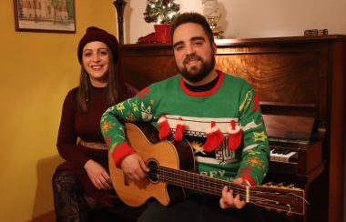 Geneviève à gauche est assise sur un banc de piano avec son frère Pierre à droite qui tient une guitare.