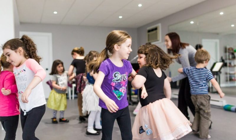 Des jeunes enfants dansant dans une salle.