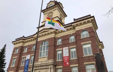 L'hôtel de ville devant un ciel gris avec le drapeau en avant à l'envers.