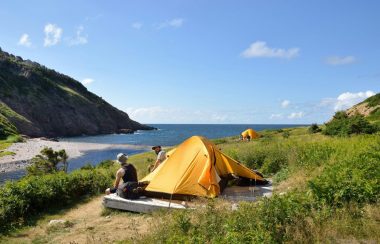 Des gens faisant du camping près de la mer.
