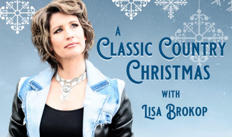 A poster for A Classic Country Christmas with Lisa Brokop standing in the foreground and a snowflake covered background.