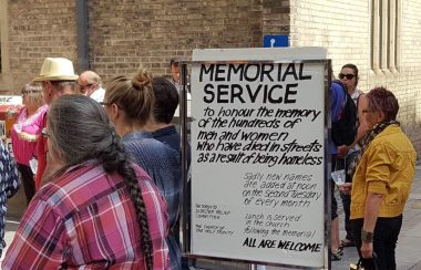 A group of people in front of a church for a memorial.