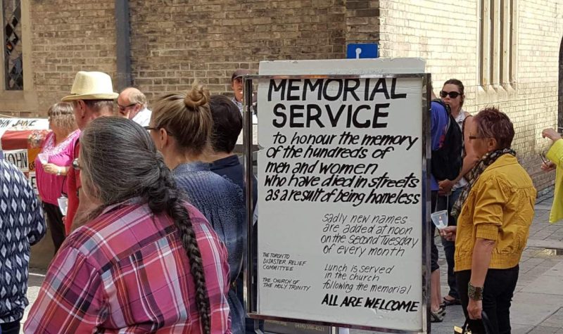 A group of people in front of a church for a memorial.