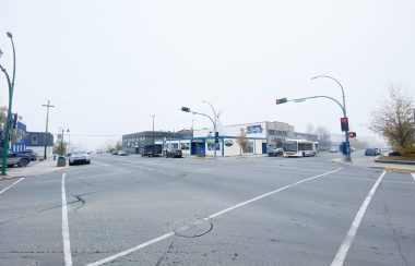 Vue panoramique d'un carrefour routier, sous un ciel gris.