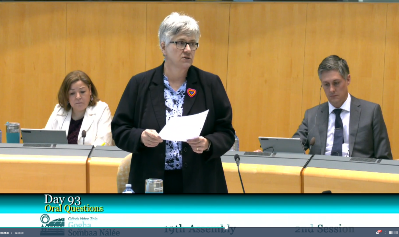 Une femme debout, document en mains, intervient dans une Assemblée.