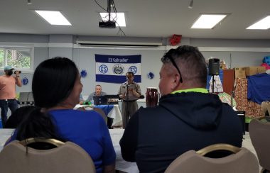 Dos personas sentadas y viendo una actuación en el festival local de El Salvador