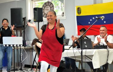 Una mujer baila frente a las banderas de Venezuela, Panamá y Costa Rica