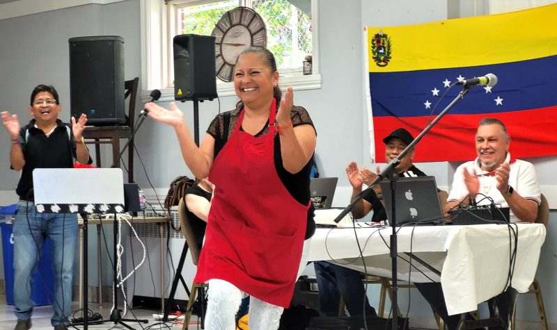 Una mujer baila frente a las banderas de Venezuela, Panamá y Costa Rica