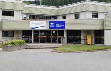 Two story building with a Terrace Northern Health Unit Sign and a B.C. Ministry of Children and Family Development sign on the front.