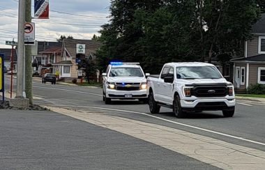 Sur la rue Canada à Saint-Quentin. Un véhicule blanc de la GRC a ses gyrophares allumés derrière une camionnette blanche.