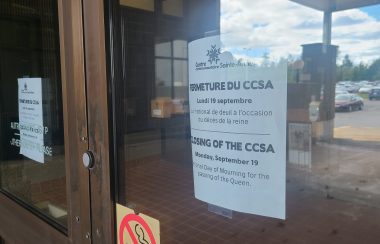 Porte vitrée du centre communautaire Sainte-Anne de Fredericton. Une affiche annonce la fermeture du centre pour le lundi 19 septembre.