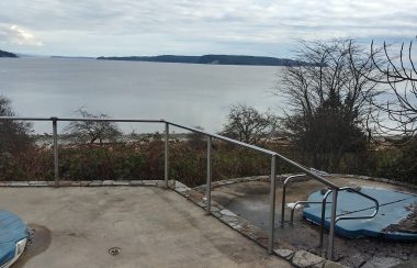 Two hottubs are covered for winter, overlooking the ocean.