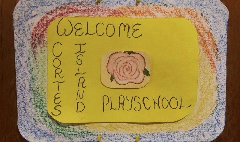 Hand drawn sign reads, “Welcome to Cortes Island Playschool”.