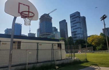 A basketball hoop with view of the Toronto skyline in background