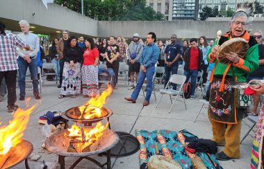 Three sacred fires are lit Elder Garry Sault sings and plays his drum to a crowd