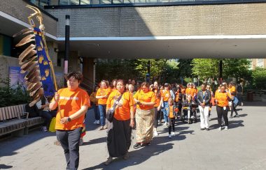 A group of people in orange shirts march on the Toronto Metropolitian University campus