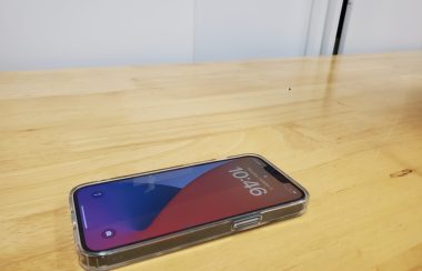 An apple Iphone on a wooden desk