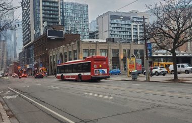 A TTC bus druing by a parkinglot downtown
