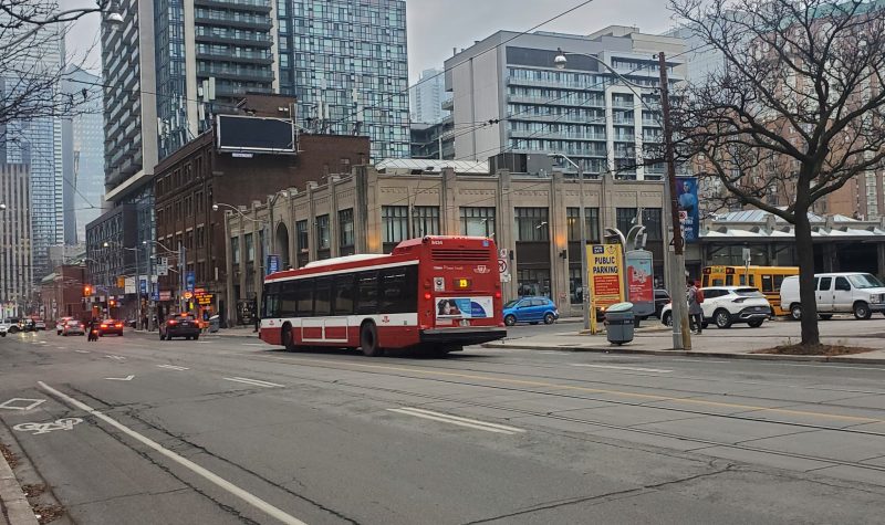 A TTC bus druing by a parkinglot downtown