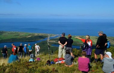 Des gens au sommet d'une montagne admirant le paysage.