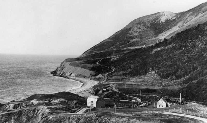 Une ancienne maison et une ancienne grange au bord de la mer au pieds des montagnes.