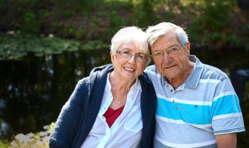 Un couple âgé assis sur un banc.
