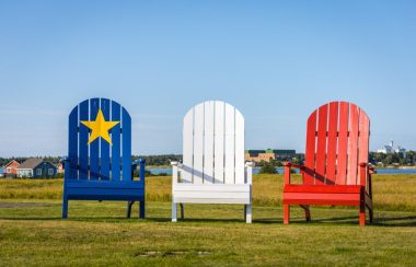 Trois grandes chaises aux couleurs du drapeau acadien, soit bleu, blanc et rouge.