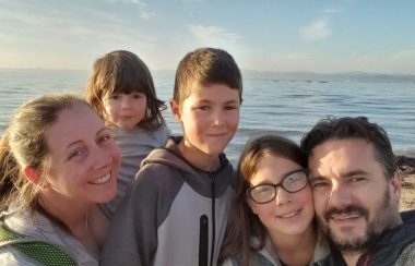 Une famille de cinq membres sur un bateau en mer par une belle journée d'été.