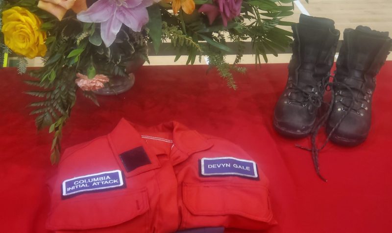 A red shirt, a pair of boots and a bouquet of flowers against a red background.