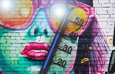 A photo of a mural in Abbotsford of a woman with sunglasses and a thermometer showing high heat