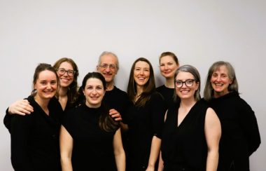 Members of the Sports Physio Plus clinic in their black uniforms standing against a white background.