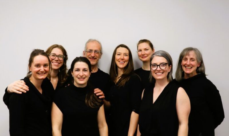 Members of the Sports Physio Plus clinic in their black uniforms standing against a white background.