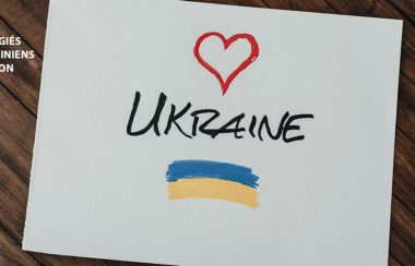 A piece of paper against a brown background that includes the word Ukraine, a red heart, and blue and yellow stripes. Réfugiés Ukrainiens Sutton is also included.