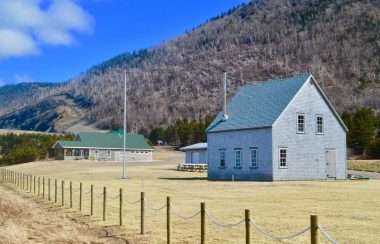 Une réplique dune ancienne maison et autres bâtiments au pied des montagnes.