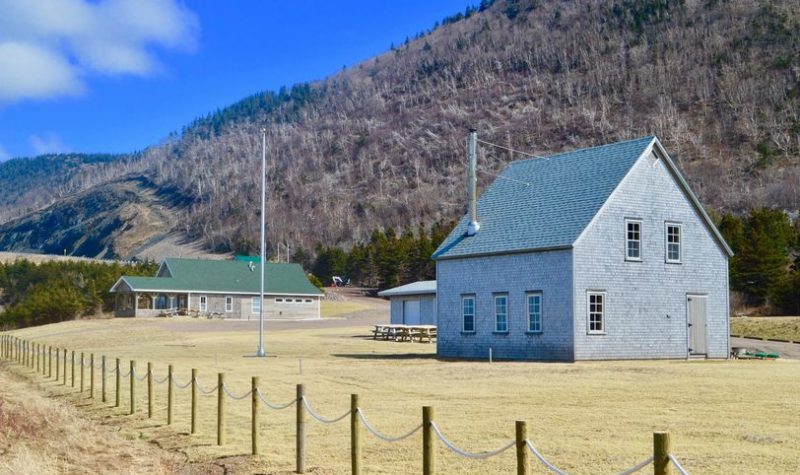 Une réplique dune ancienne maison et autres bâtiments au pied des montagnes.