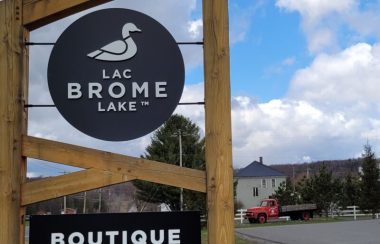 A picture of the Brome Lake Ducks sign at the entrance to the Brome Lake Ducks farm in Knowlton. The sign is round and features a duck with the words Lac Brome Lake.