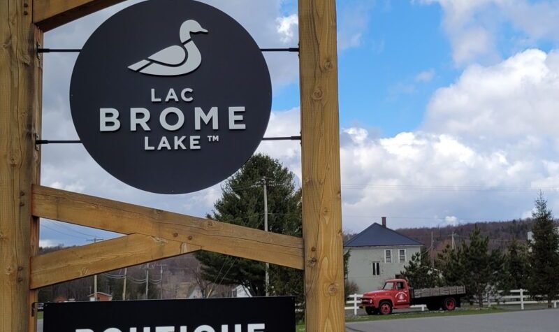 A picture of the Brome Lake Ducks sign at the entrance to the Brome Lake Ducks farm in Knowlton. The sign is round and features a duck with the words Lac Brome Lake.
