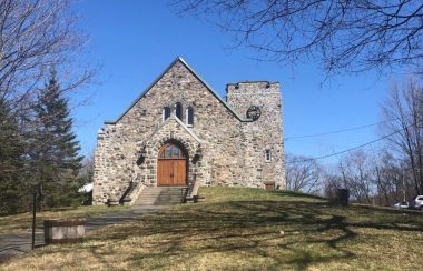 A picture of the front of St. Paul's Anglican Church in Knowlton. The church is made out of grey stone.