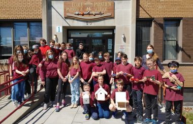 Pictured is Jaqueline Quesnelle with some of the grade six students involved in the project. They are dressed in their maroon red uniforms standing in front of Parkview Elementary School.