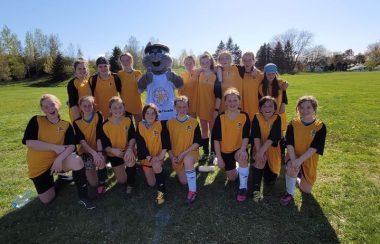 Des jeunes filles de soccer portant des chandails jaunes.