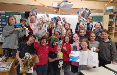 Pictured is Sonia Bahl and her grade four students standing in front of the blackboard holding some of the items they have collected.