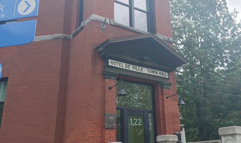 The front of the town hall for the municipality of Brome Lake. It is an old brick building, with two large windows in the front, with the Town of Brome Lake posted just above the door.