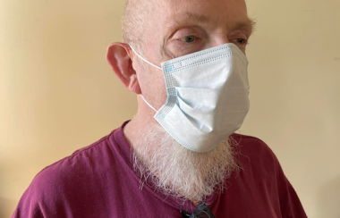 A man wearing a COVID-19 mask and a Mount Allison Mounties t-shirt.