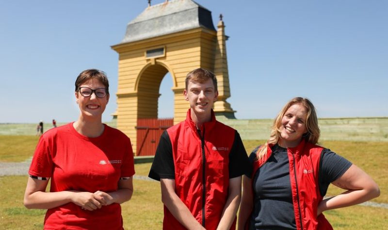 Un homme et deux femmes portant des chandails rouges .